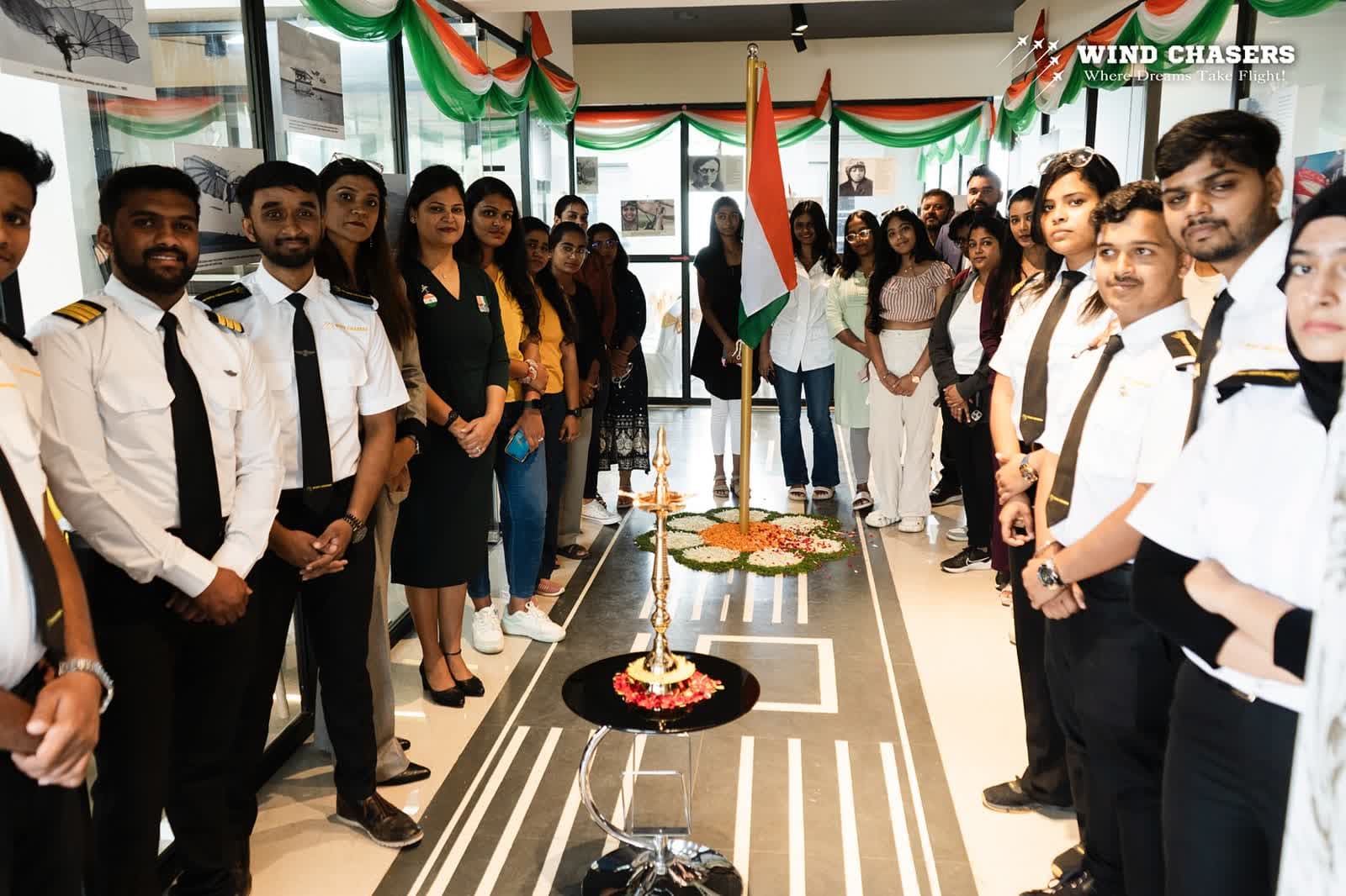 Attendees and WindChasers cadets gathered around the Indian flag for the Independence Day ceremony