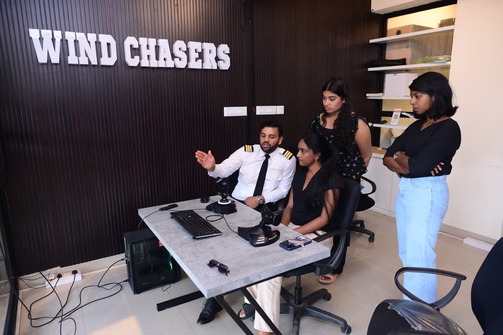 An instructor guiding attendees at the flight simulator controls